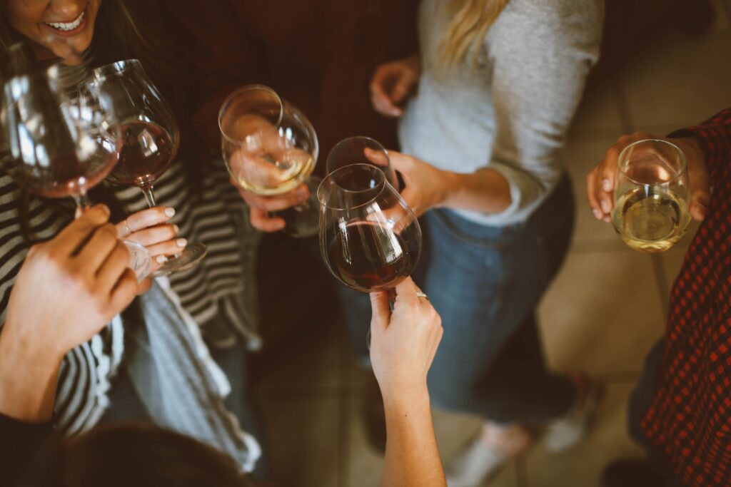 Friends sharing wine while a woman experiences social anxiety.